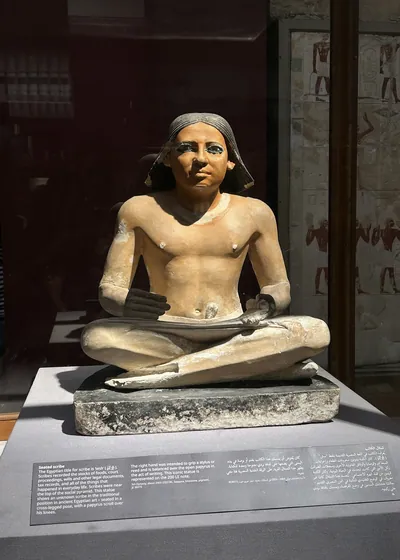 Cairo, Egypt - Feb 4, 2025: statue of a seated scribe from ancient Egypt, noted for lifelike detail, displayed at the Egyptian Museum in Cairo.