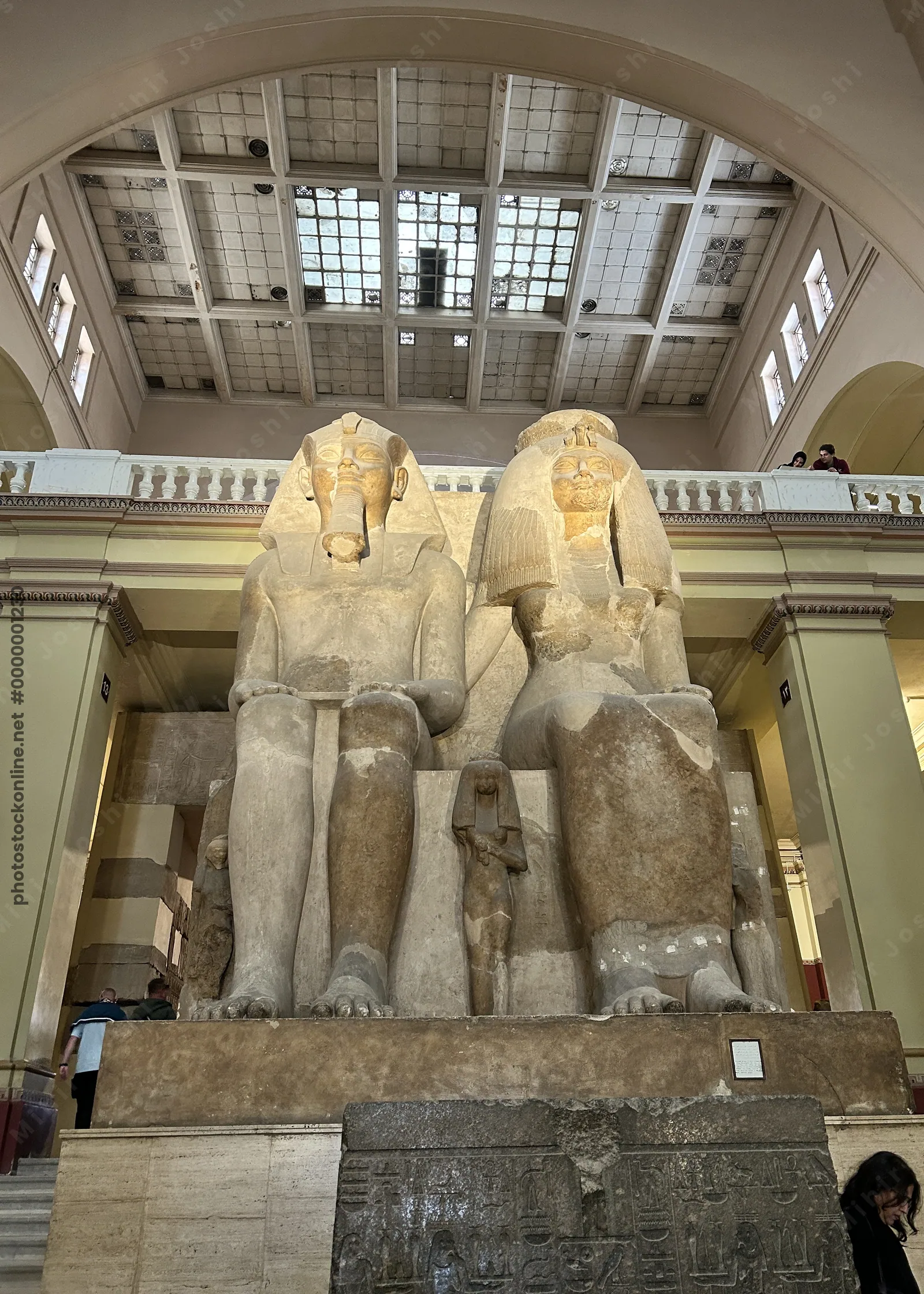 Cairo, Egypt - Feb 4, 2025: Massive seated statue of Pharaoh Amenhotep III with Queen Tiye and daughters, symbolizing royal power and family, displayed at the Egyptian Museum in Cairo.