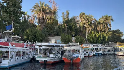 Aswan, Egypt - Feb 7, 2025: Small boats docked along the Nile near the Aswan Botanical Garden in Aswan, Egypt