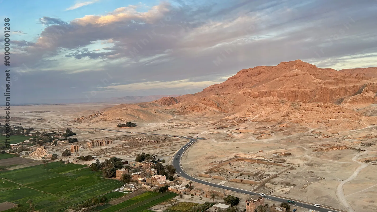Luxor, Egypt - Feb 10, 2024:Scenic aerial view of ancient ruins, green fields, and desert mountains near Luxor, Egypt, taken during a hot air balloon ride.