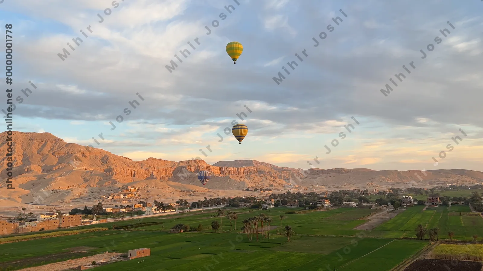 Hot air balloons over Luxor at sunrise with deser