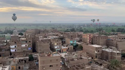 Hot air balloons floating above Luxor town and fa