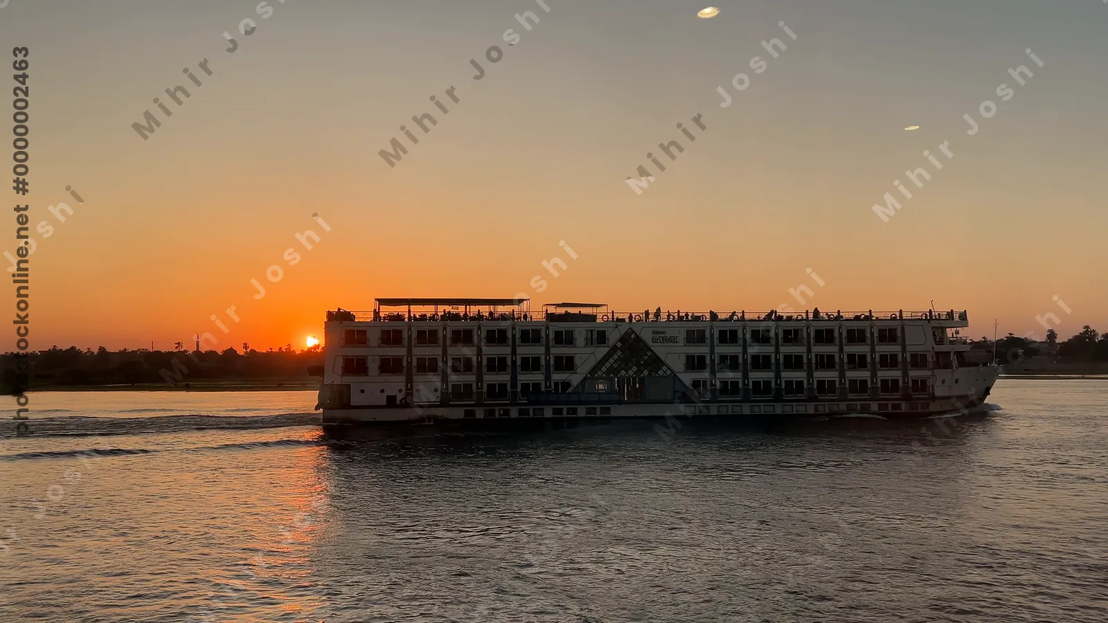 Nile cruise ships sailing at sunset in Aswan, Egy