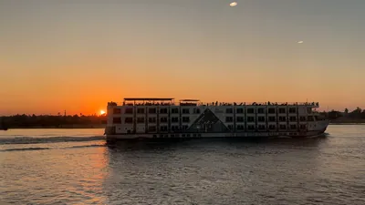 Nile cruise ships sailing at sunset in Aswan, Egy