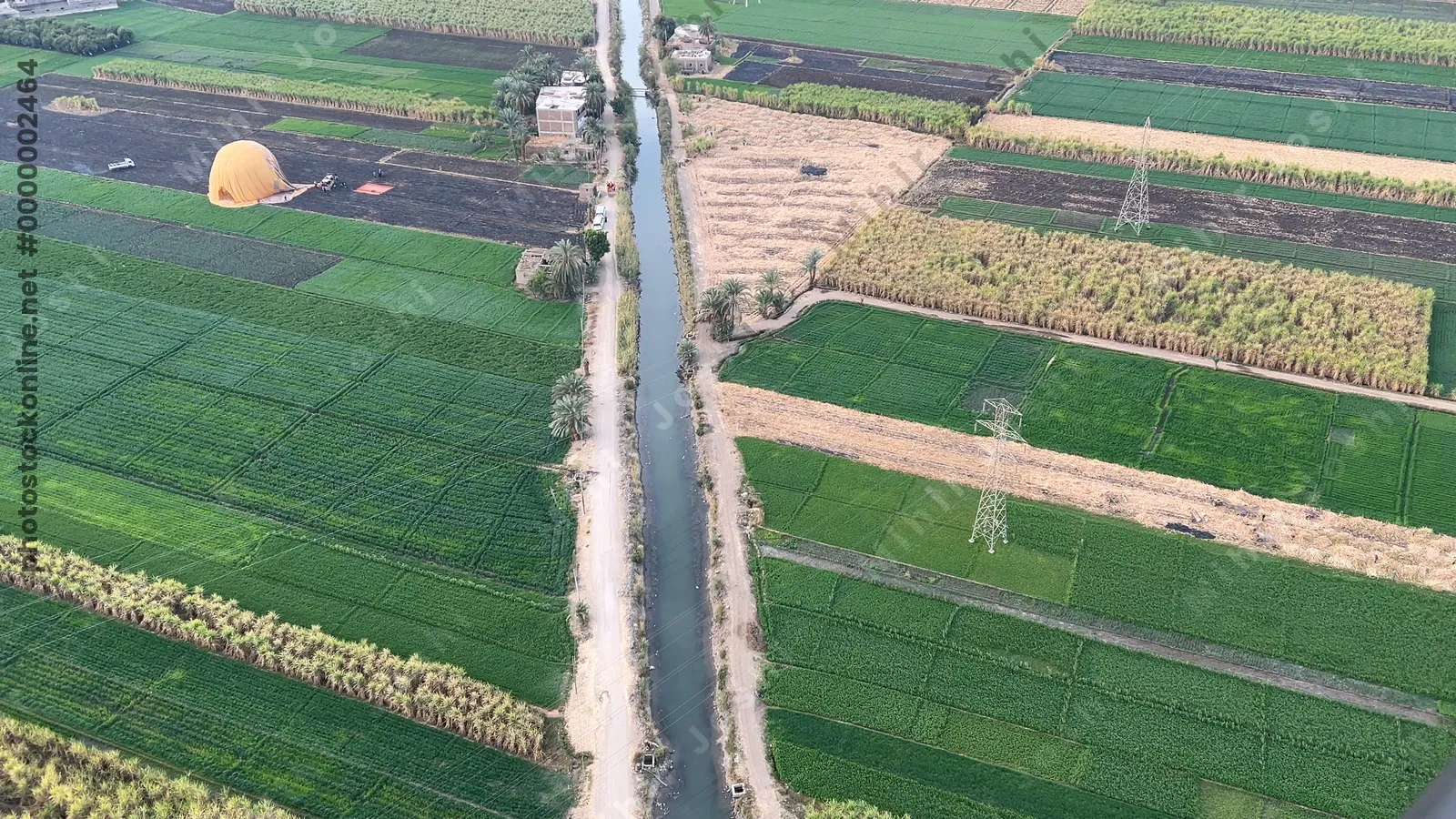 Aerial view of farmland and canal with hot air ba