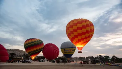 Colorful hot air balloons prepare for sunrise fli