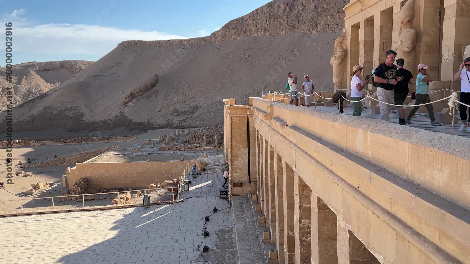 Luxor, Egypt - Feb 12, 2025: Tourists on the middle terrace of the Mortuary Temple of Queen Hatshepsut at Deir el-Bahari, showing temple architecture and surrounding cliffs.