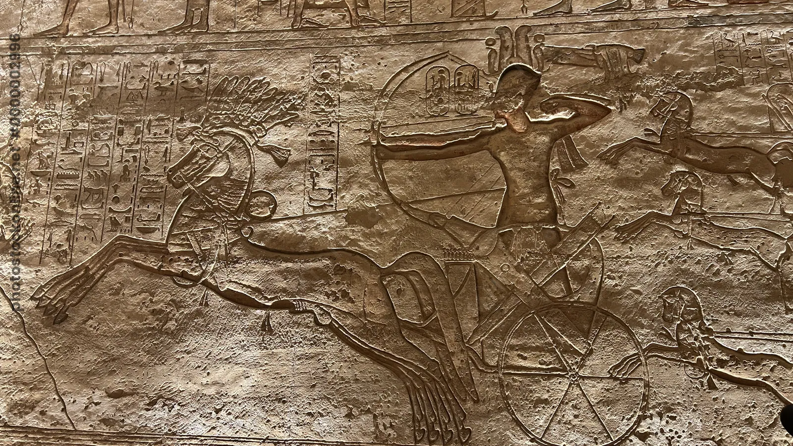 Aswan, Egypt - Feb 8, 2025: Ancient battle relief at Abu Simbel showing Pharaoh Ramesses II in a chariot with bow, part of the Battle of Kadesh scenes