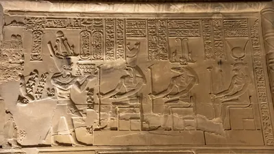 Wall relief at Kom Ombo shows Pharaoh worshipping Horus, Sobek, and Hathor.