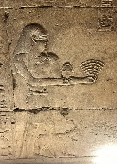 Edfu, Egypt - Feb 9, 2025: Ancient Egyptian relief at the Temple of Horus depicting a ritual fan-shaped offering, popularly nicknamed the Wi-Fi logo relief.