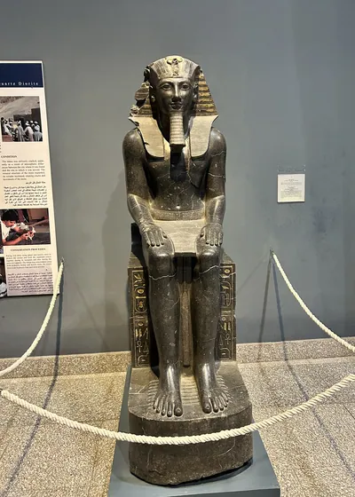 Luxor, Egypt - Feb 9, 2025: Ancient seated statue of Pharaoh Thutmose III from Egypt, displayed in the Luxor Museum as part of its archaeological collection.