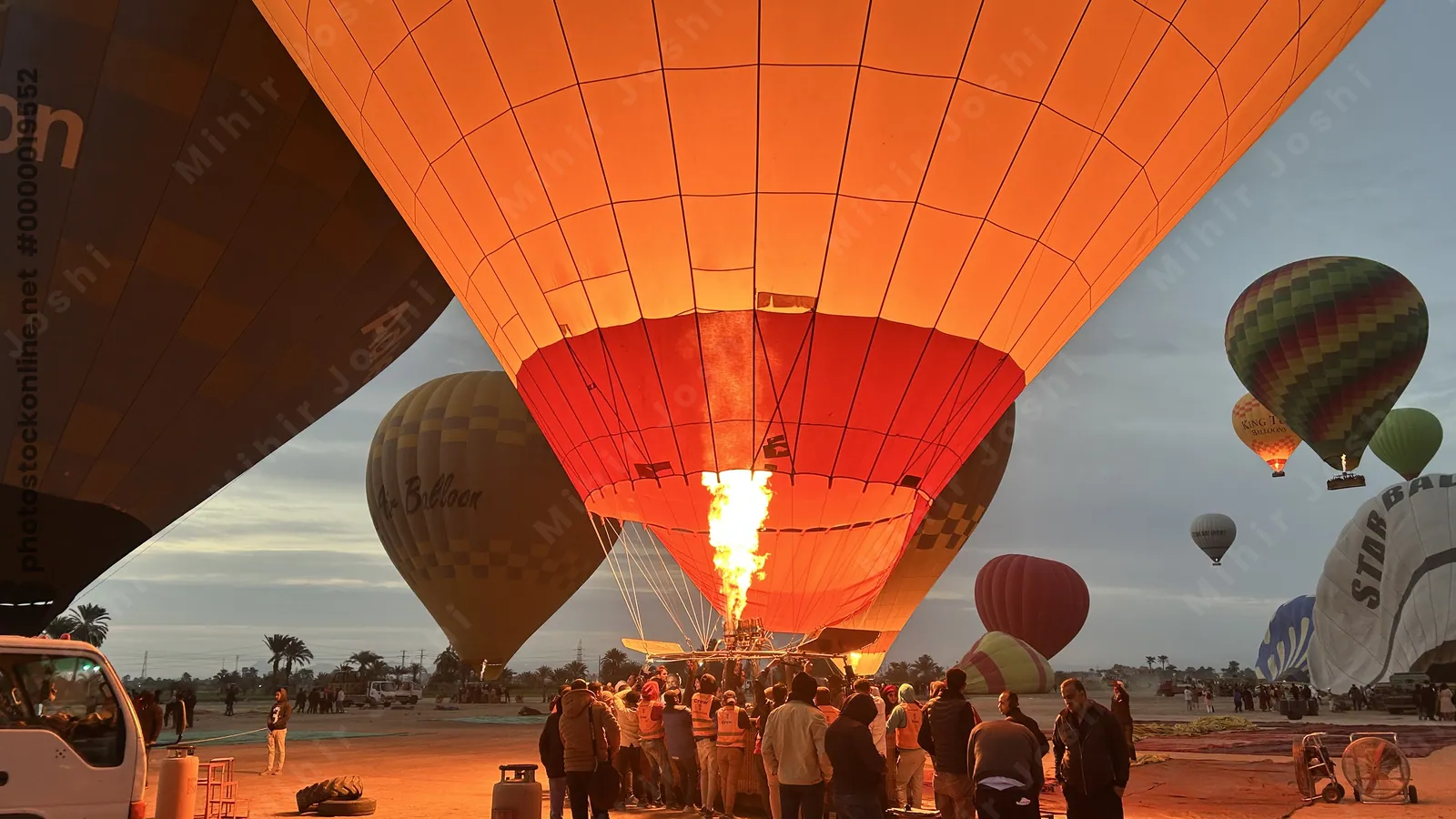 Luxor, Egypt - Feb 10, 2025: Hot air balloons being filled with air at dawn in preparation for a sunrise flight over Luxor, Egypt.