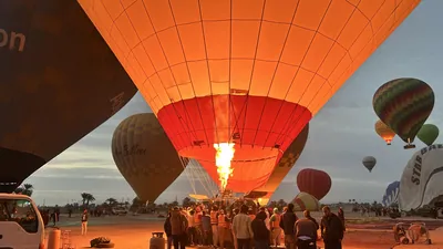 Luxor, Egypt - Feb 10, 2025: Hot air balloons being filled with air at dawn in preparation for a sunrise flight over Luxor, Egypt.