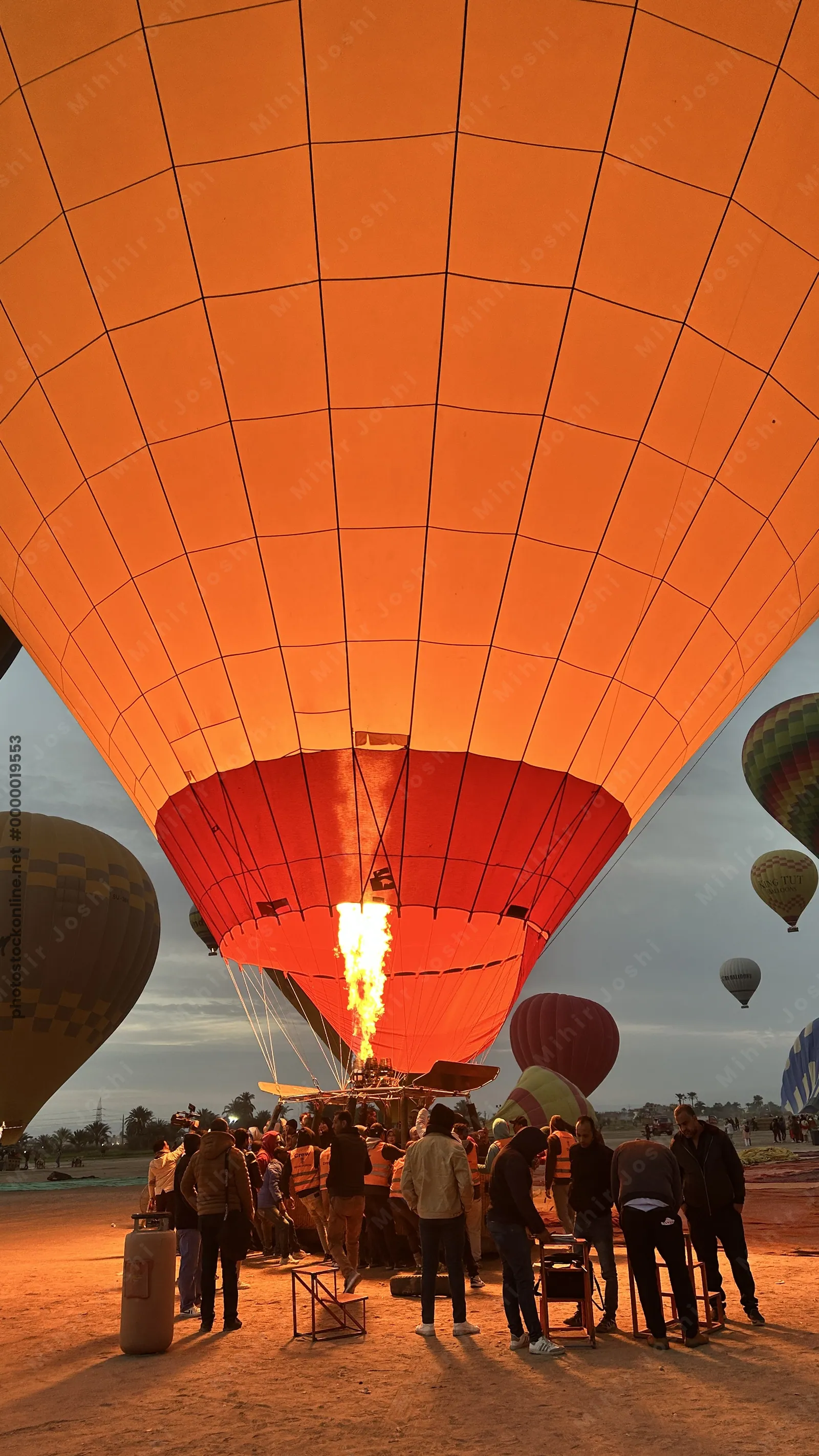 Luxor, Egypt - Feb 10, 2025: Hot air balloons being filled with air at dawn in preparation for a sunrise flight over Luxor, Egypt.