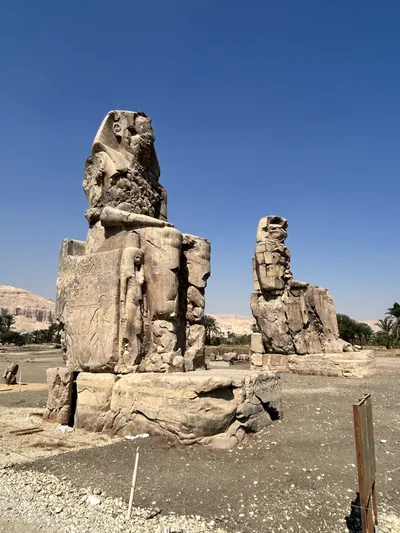 Luxor, Egypt - Feb 11, 2025: The Colossi of Memnon, two massive seated statues of Pharaoh Amenhotep III, located on the west bank of the Nile near Luxor, Egypt.