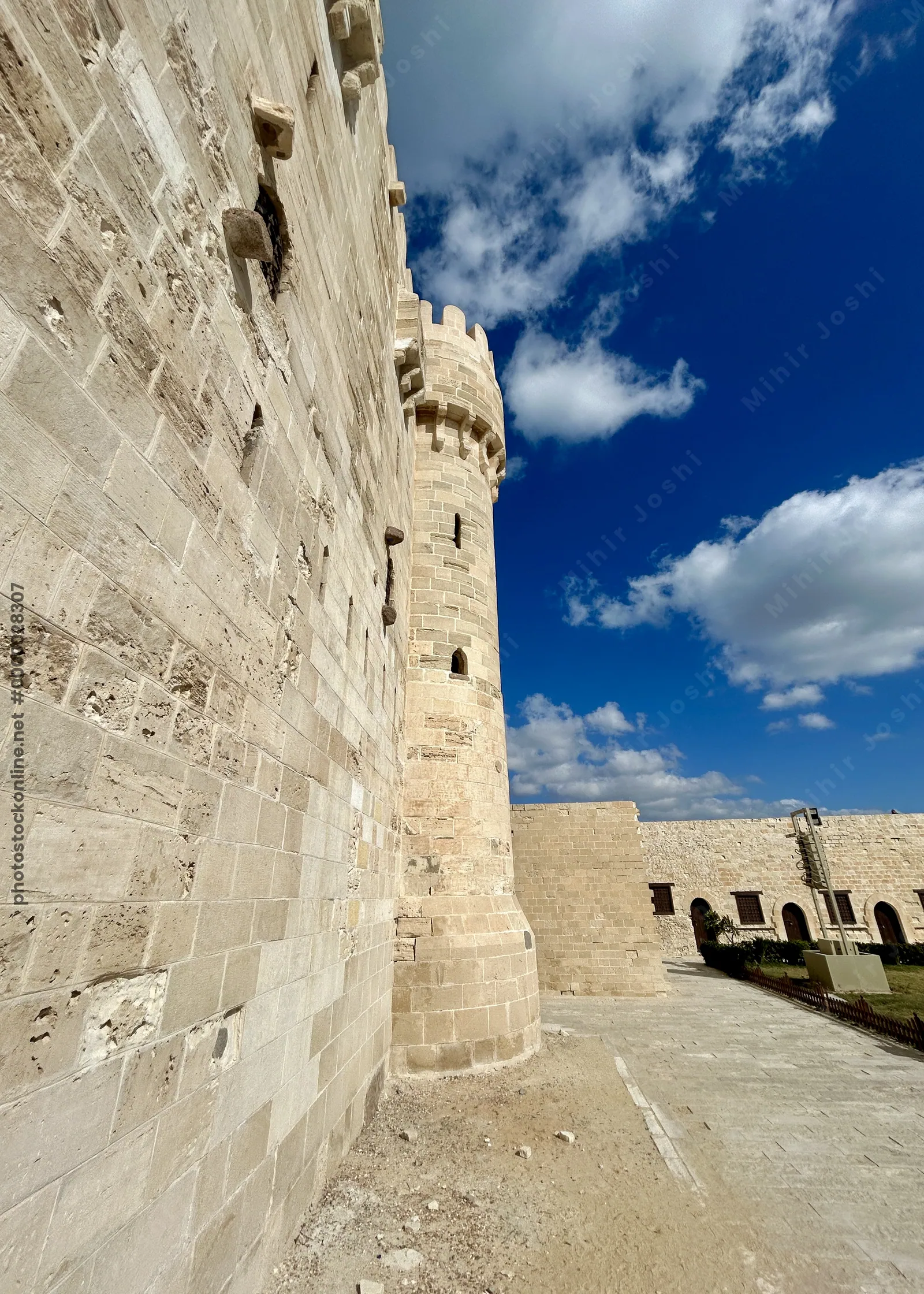 Alexandria, Egypt - Feb 13, 2025: Detailed view of fortified stone wall and tower of the medieval Citadel of Qaitbay fortress.