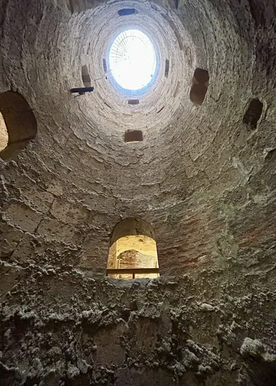 Alexandria, Egypt - Feb 13, 2025: View looking upward through a circular shaft with stone walls at the Catacombs of Kom El Shoqafa, a Greco-Roman necr