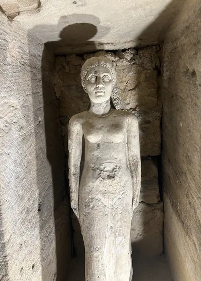 Alexandria, Egypt - Feb 13, 2025: Weathered stone statue of a female figure inside the Catacombs of Kom El Shoqafa, a Greco-Roman necropolis and archa