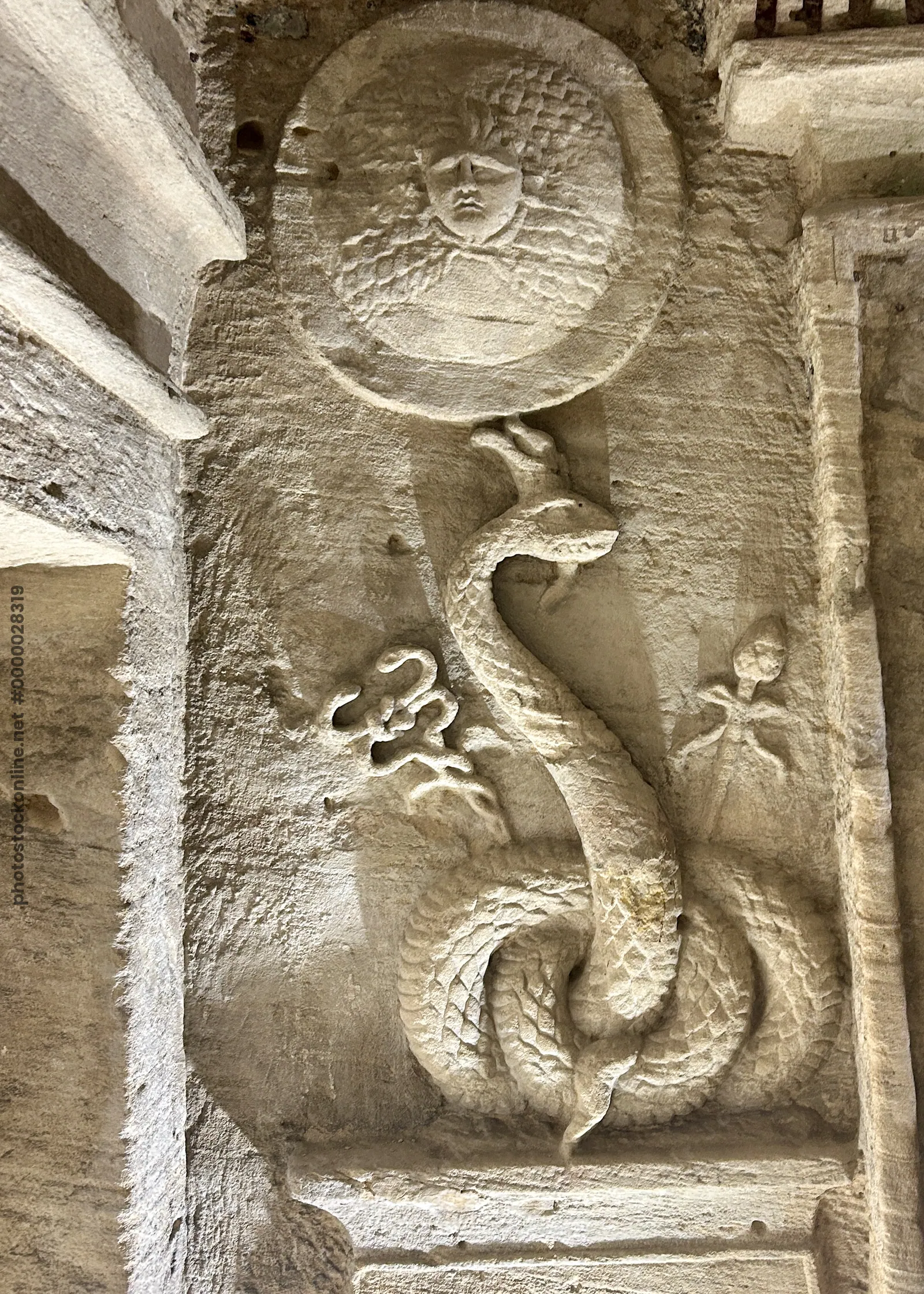 Alexandria, Egypt - Feb 13, 2025: Stone carving depicting the Agathos Daimon serpent at the Catacombs of Kom El Shoqafa, a Greco-Roman necropolis in A