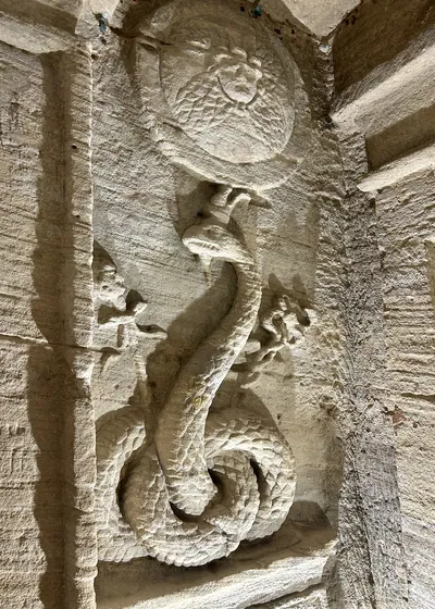 Alexandria, Egypt - Feb 12, 2025: Stone carving depicting the Agathos Daimon serpent at the Catacombs of Kom El Shoqafa, a Greco-Roman necropolis in A