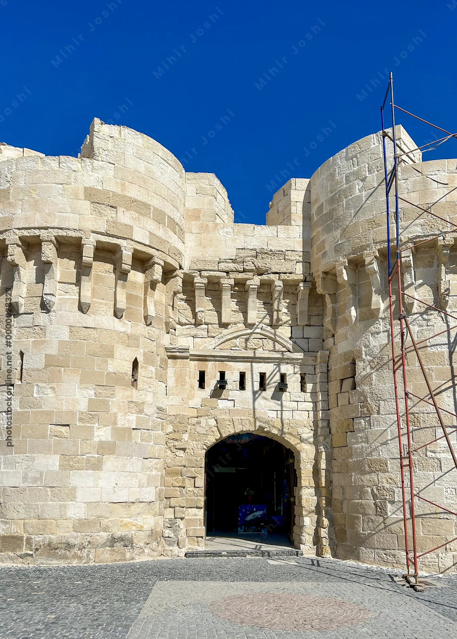 Alexandria, Egypt - Feb 13, 2025: Stone entrance gate of the medieval Citadel of Qaitbay, a 15th century fortress on the Mediterranean coast of Alexan