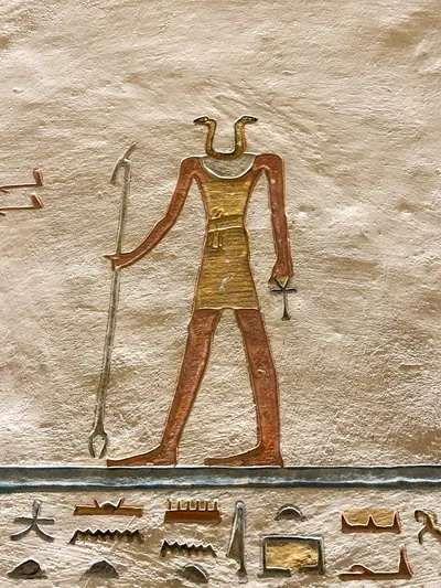 Valley of the Kings, Egypt - Feb 11, 2025: Painted relief of a snake-headed figure holding a spear and ankh in Tomb KV9.