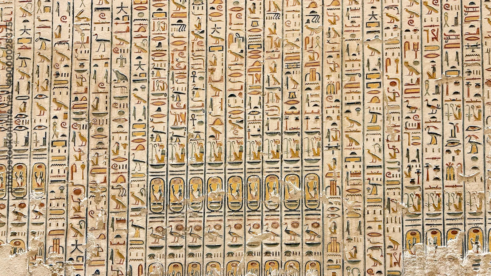 Luxor, Egypt - Feb 11, 2025: Ancient hieroglyphic inscriptions carved and painted on a wall inside a royal tomb at the Valley of the Kings.