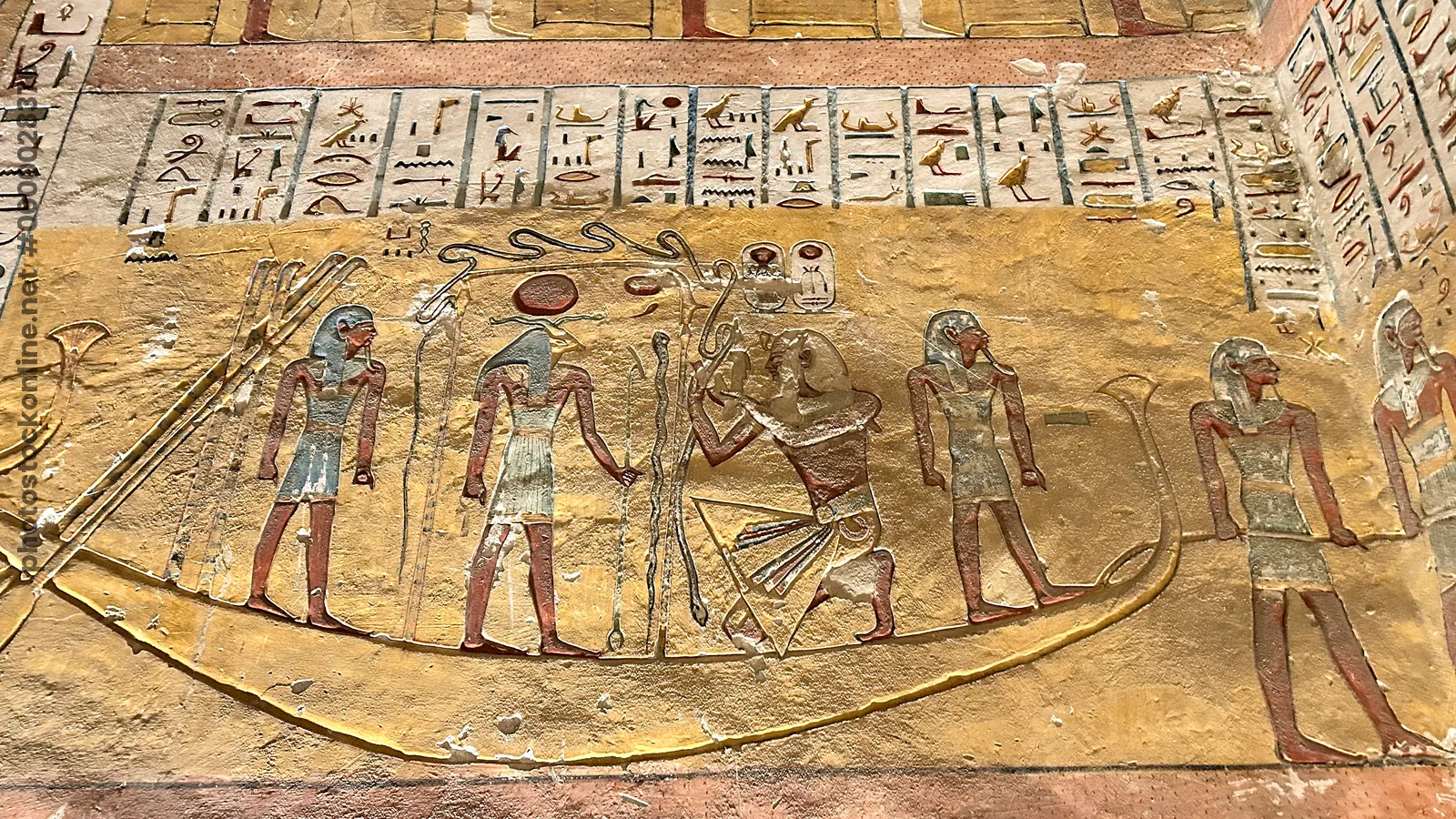 Luxor, Egypt - Feb 11, 2025: Hieroglyphic inscriptions and painted relief depicting the god Khnum with Ramesses IV in a solar barque. Scene from the T
