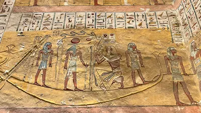 Luxor, Egypt - Feb 11, 2025: Hieroglyphic inscriptions and painted relief depicting the god Khnum with Ramesses IV in a solar barque. Scene from the T