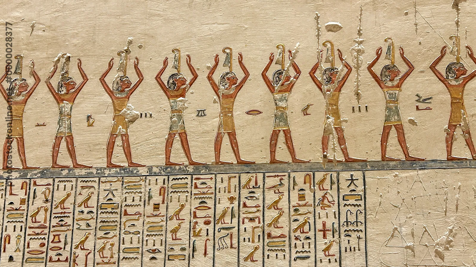 Luxor, Egypt - Feb 2025: Wall relief in the Valley of the Kings depicting a procession of figures performing ritual gestures with hieroglyphic inscrip