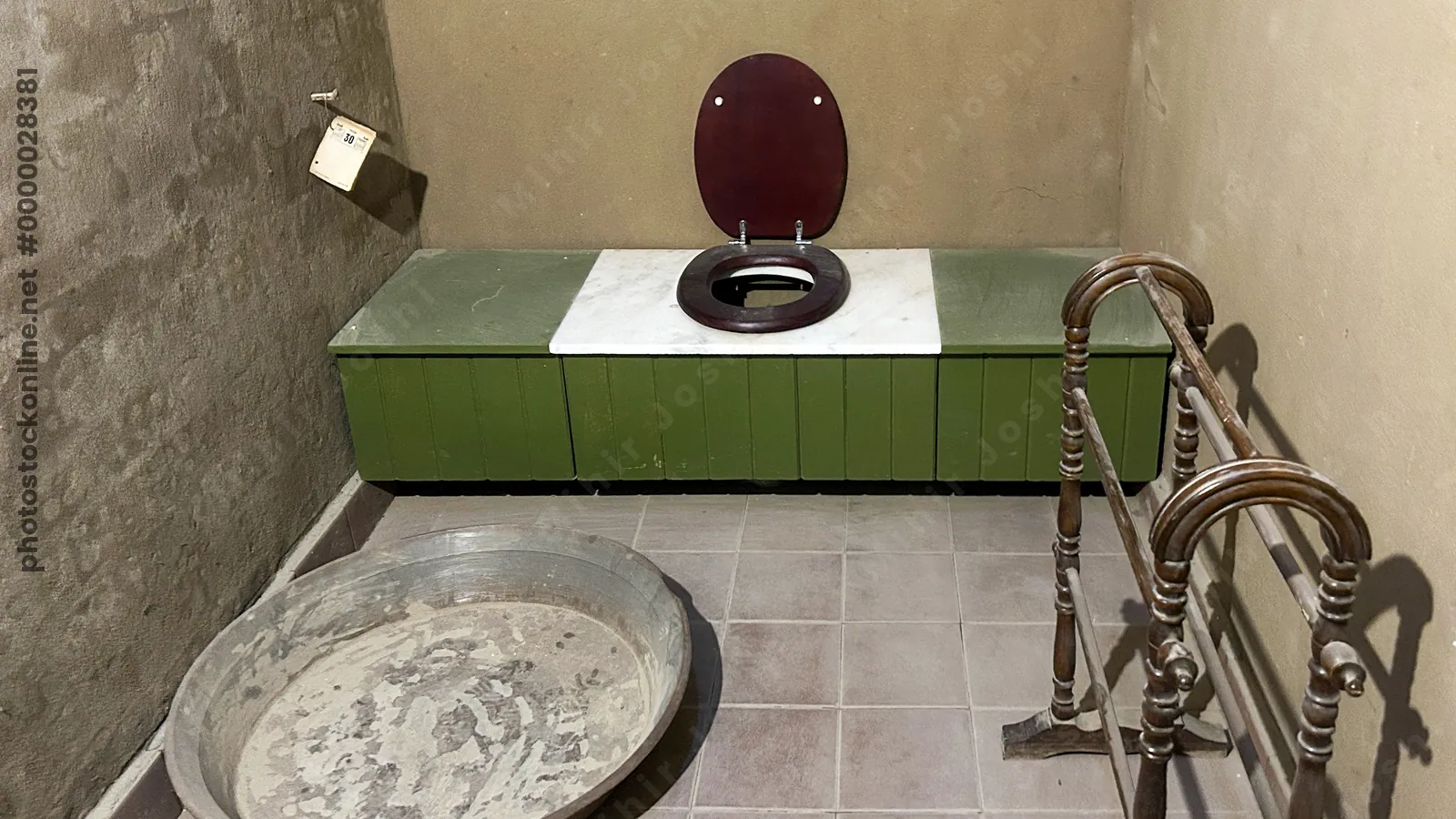 Luxor, Egypt - Feb 11, 2025: Historic bathroom interior at Howard Carter House, with old wooden toilet seat, basin, and towel rack