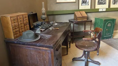 Luxor, Egypt - Feb 11, 2025: Study interior at Howard Carter House, showing wooden desk with typewriter, magnifying glass, oil lamp, chair, and safe.