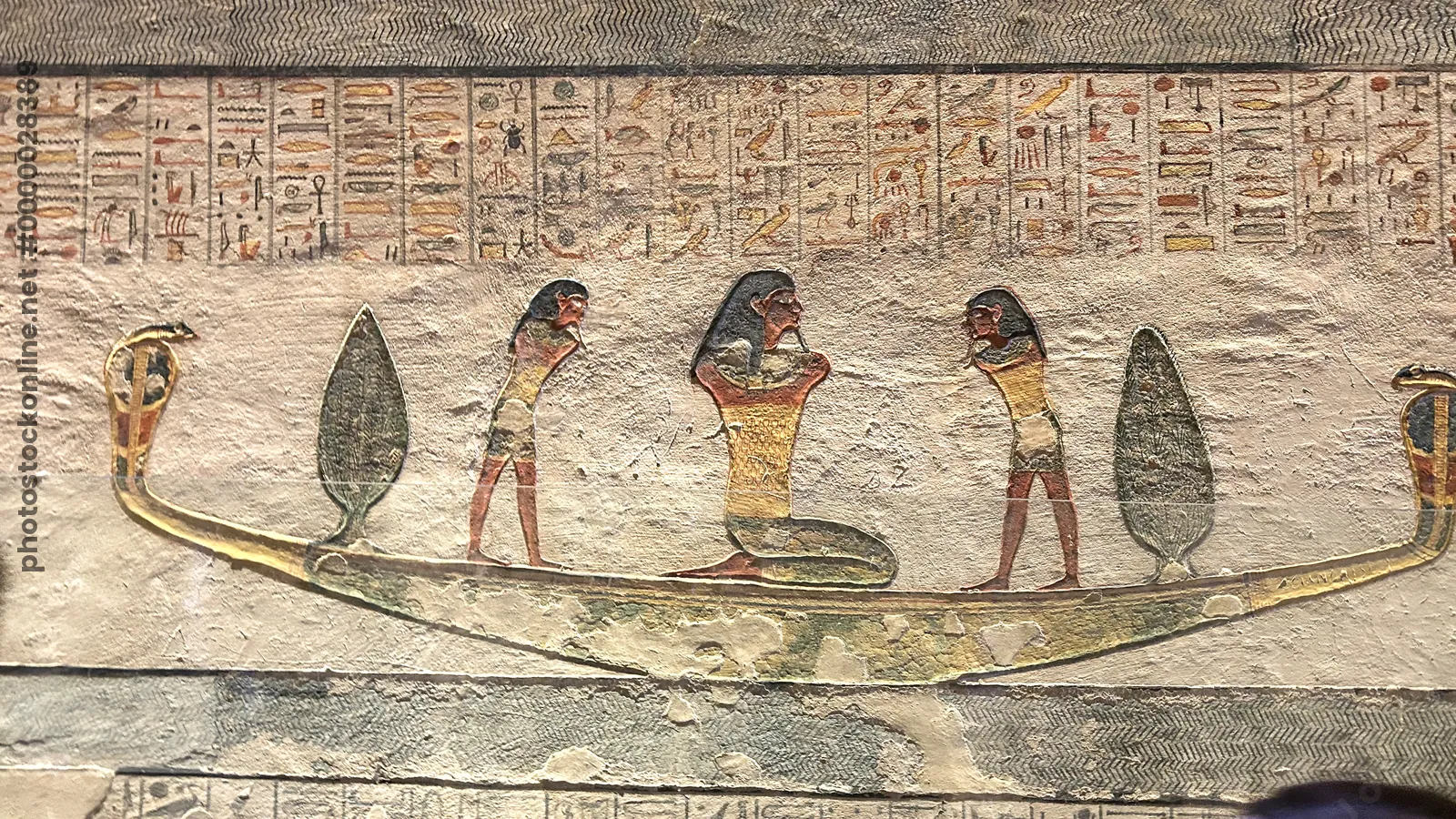 Luxor, Egypt - Feb 11, 2025: Ancient painted wall relief from the Tomb of Ramesses IV showing a divine bark with standing and kneeling figures, surrou