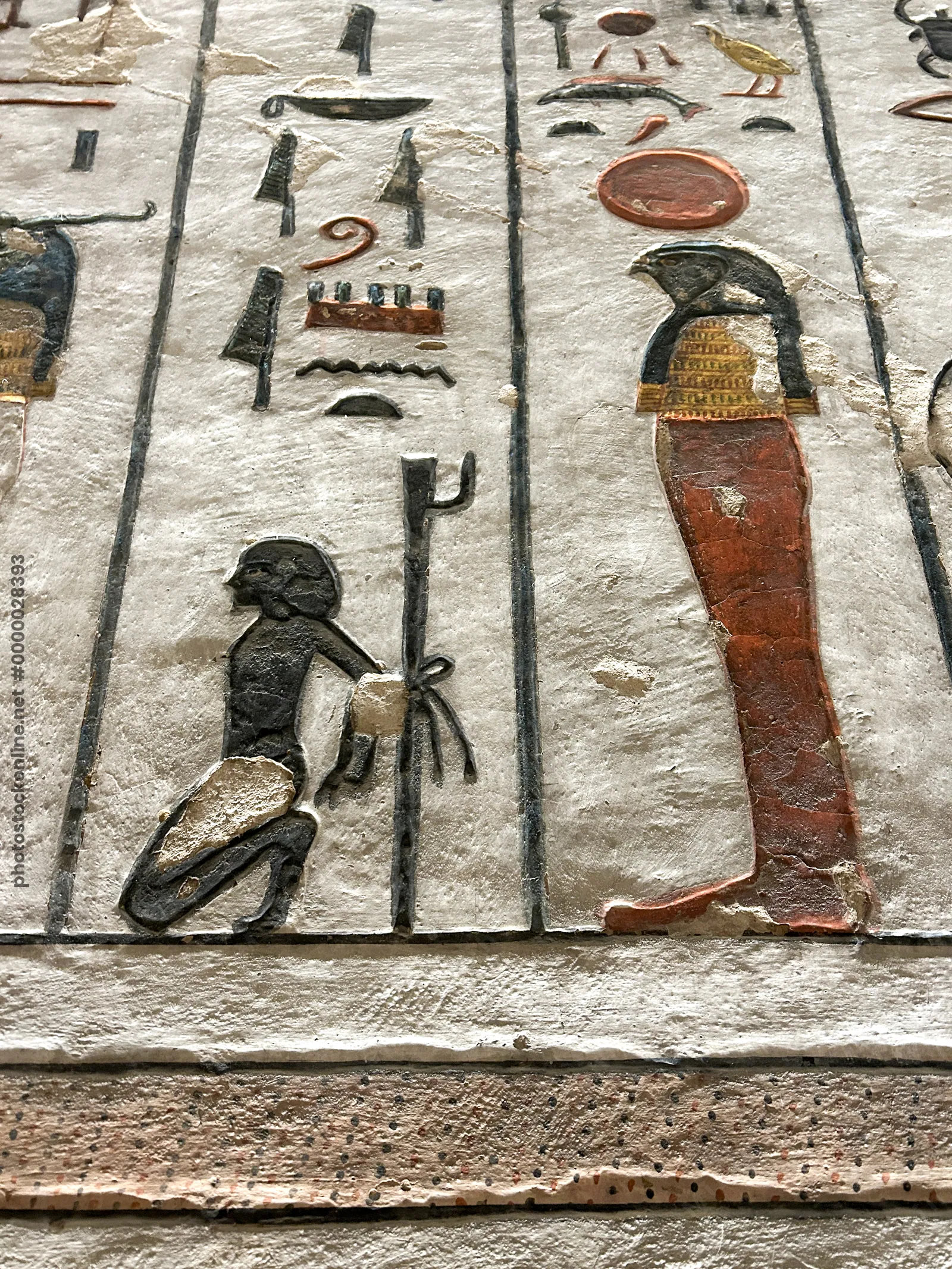 Luxor, Egypt - Feb 11, 2025: painted wall relief from the Tomb of Ramesses III depicting a falcon-headed deity with solar disk and a kneeling captive