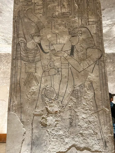 Luxor, Egypt - Feb 11, 2025: Unfinished wall relief from KV17, the Tomb of Seti I, depicting a king making an offering to a deity, drawn in outline wi