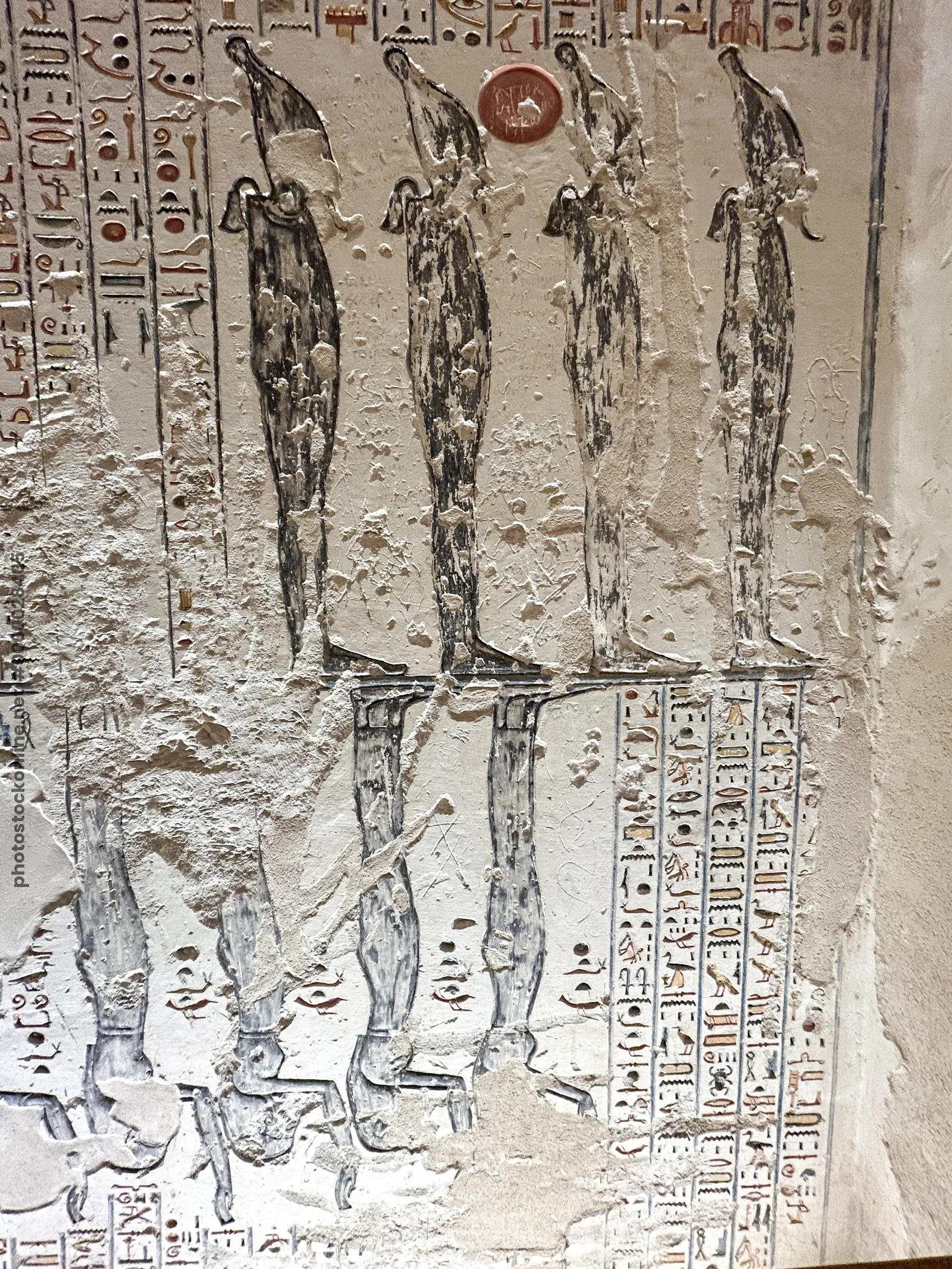 Luxor, Egypt - Feb 11, 2025: Ancient relief depicting multiple standing deities with tall headdresses and hieroglyphic inscriptions in a tomb at the V