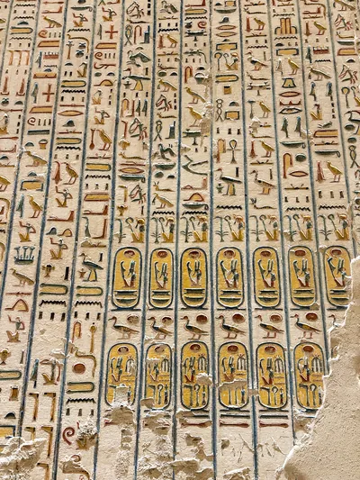 Luxor, Egypt - Feb 11, 2025: Ancient hieroglyphic wall inscriptions with royal cartouches preserved in a tomb at the Valley of the Kings, Egypt.