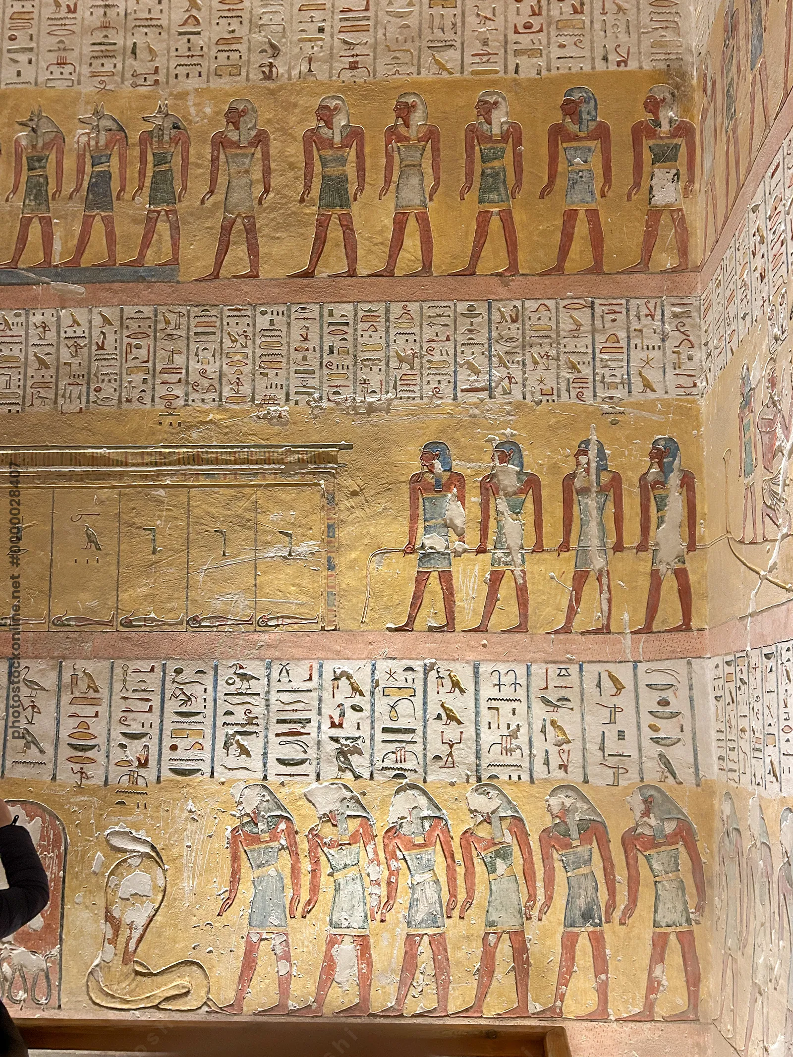 Luxor, Egypt - 11-Feb-2025: Wall paintings inside a tomb in the Valley of the Kings, depicting rows of ancient Egyptian deities with hieroglyphs on a