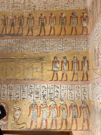 Luxor, Egypt - 11-Feb-2025: Wall paintings inside a tomb in the Valley of the Kings, depicting rows of ancient Egyptian deities with hieroglyphs on a
