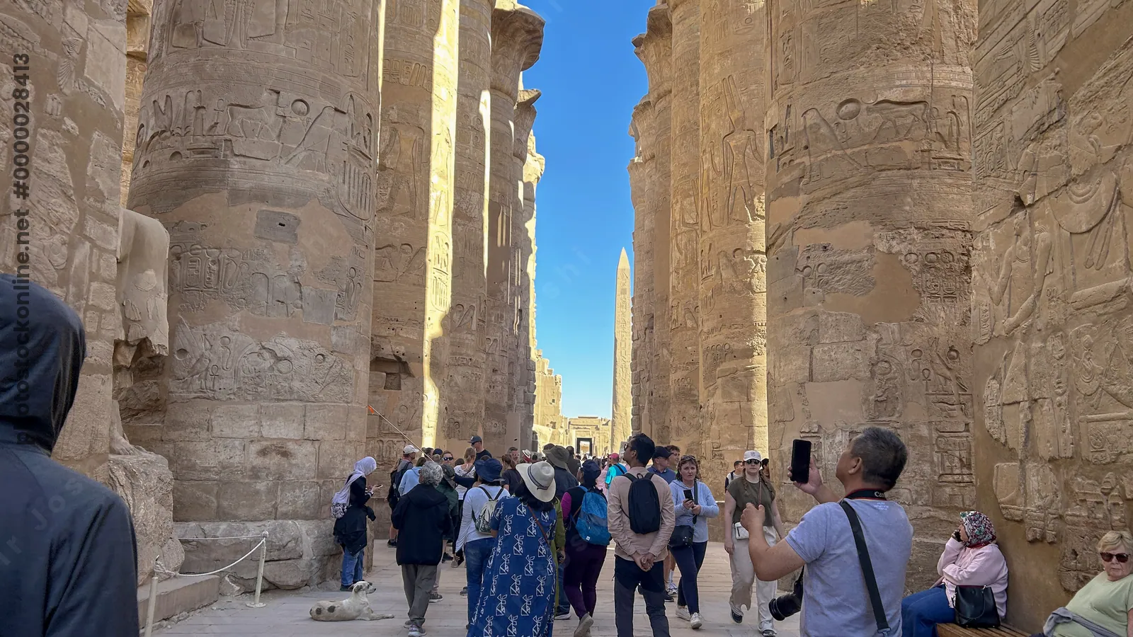 Karnak Temple, Luxor, Egypt - Feb 10, 2025: Visitors explore the Great Hypostyle Hall, walking among massive sandstone columns covered in hieroglyphic