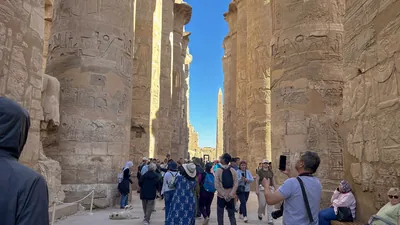 Karnak Temple, Luxor, Egypt - Feb 10, 2025: Visitors explore the Great Hypostyle Hall, walking among massive sandstone columns covered in hieroglyphic
