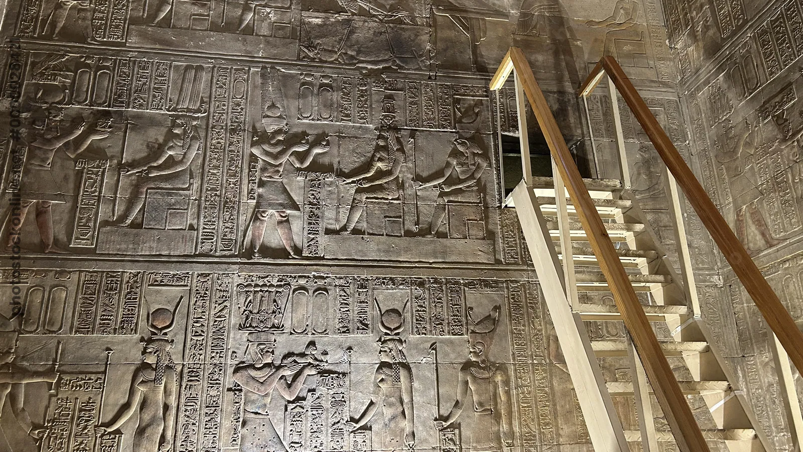 Dendera, Egypt - Feb 10, 2025: Interior of the Temple of Hathor at Dendera with a modern ladder leading to the opening of a secret chamber, surrounded