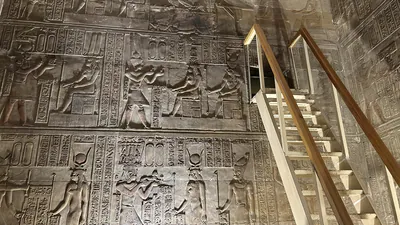 Dendera, Egypt - Feb 10, 2025: Interior of the Temple of Hathor at Dendera with a modern ladder leading to the opening of a secret chamber, surrounded