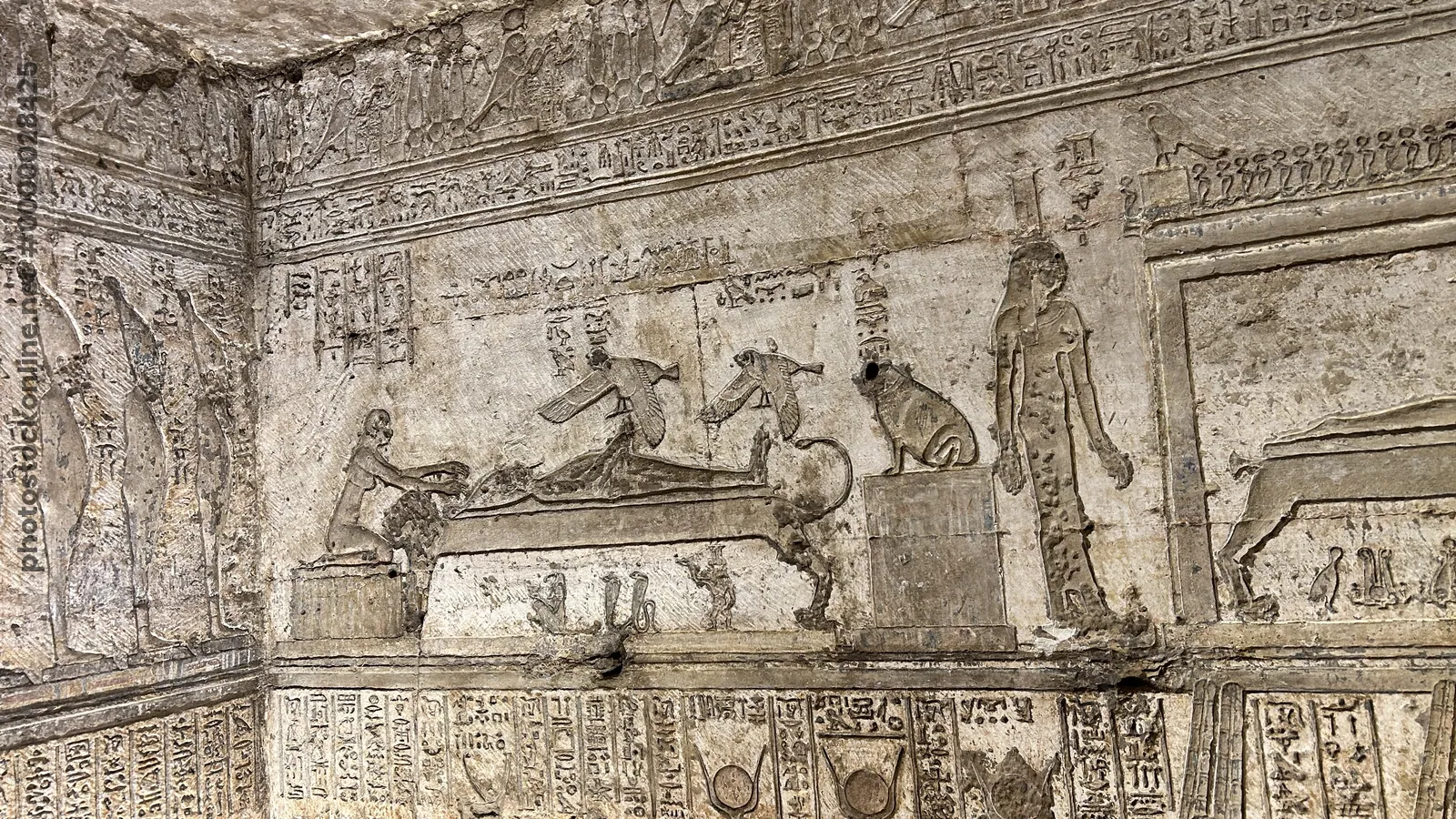 Dendera, Egypt - Feb 10, 2025: Ancient wall relief showing Osiris lying on a bier and Isis in the form of a kite above him, representing the conceptio