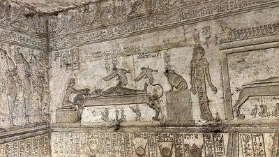 Dendera, Egypt - Feb 10, 2025: Ancient wall relief showing Osiris lying on a bier and Isis in the form of a kite above him, representing the conceptio