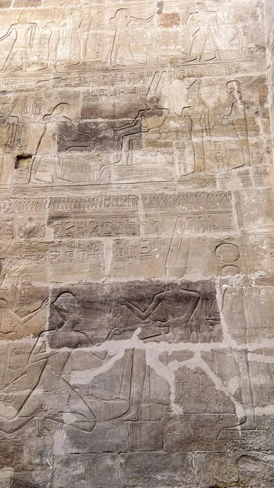 Karnak Temple, Luxor, Egypt - Feb 10, 2025: Ancient stone relief showing figures and hieroglyphics on temple walls, highlighting pharaonic artistry.