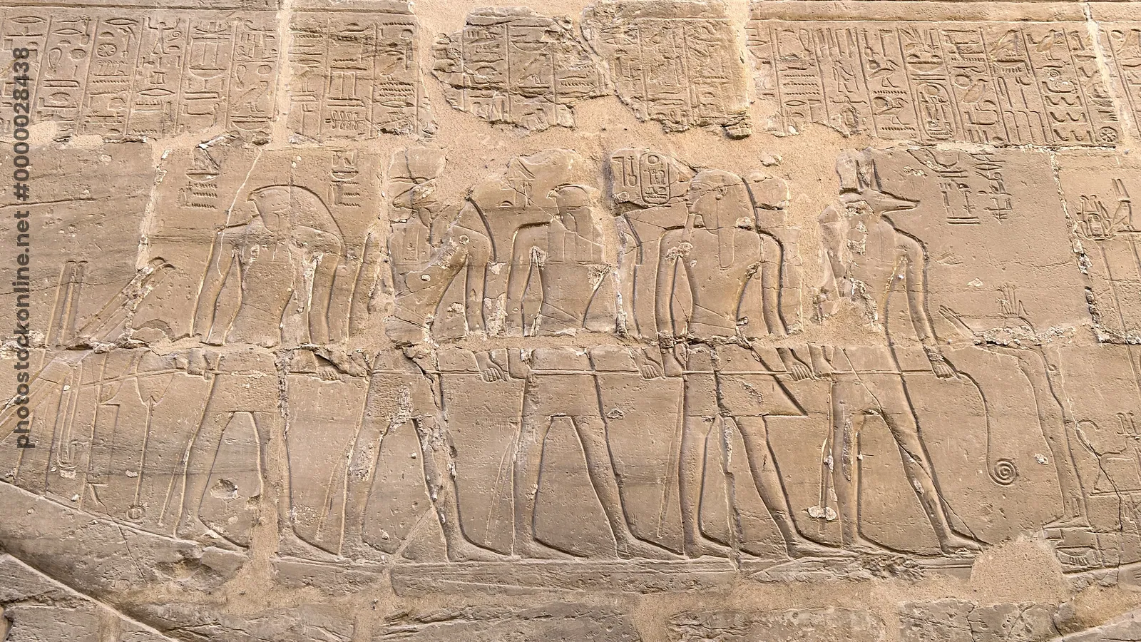Luxor, Egypt - Feb 10, 2025: Ancient sandstone relief depicting Egyptian gods standing on a sacred ceremonial barque at Karnak Temple in Luxor, Egypt.