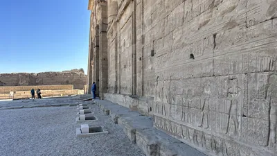 Dendera, Egypt - Feb 10, 2025: Ancient stone reliefs and hieroglyphs carved into the outer wall of the Dendera Temple complex in Egypt.