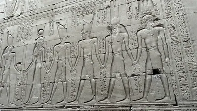 Edfu, Egypt - Feb 9, 2025: A carved sandstone relief at the Temple of Horus in Edfu depicting a procession of gods and the pharaoh, richly inscribed w