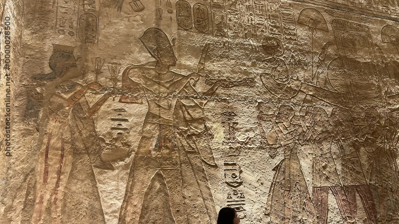 Aswan, Egypt - Feb 8, 2025: Ancient relief at Abu Simbel showing Pharaoh with priests presenting offerings and a sacred barque in a temple ritual.